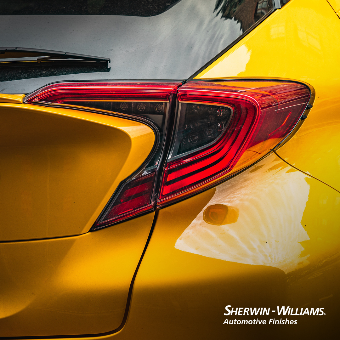 Parte trasera de un coche amarillo con acabado de pintura brillante, utilizando productos de Sherwin Williams, disponible en Ferreterías Guevara.